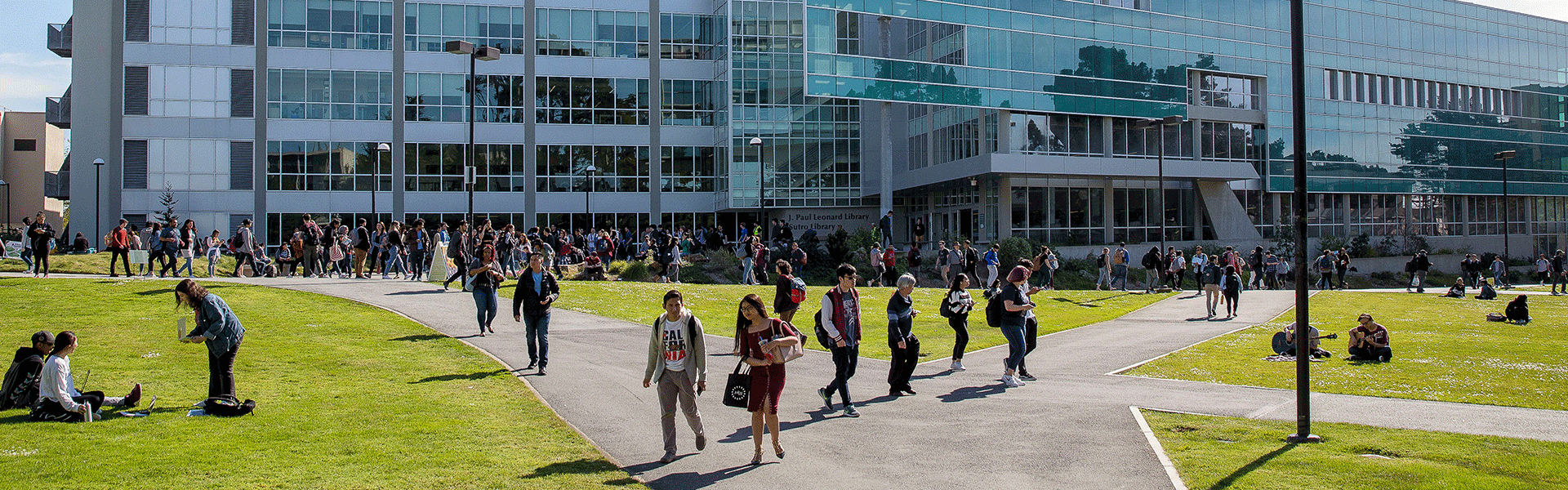 Students walking on campus in front of the library